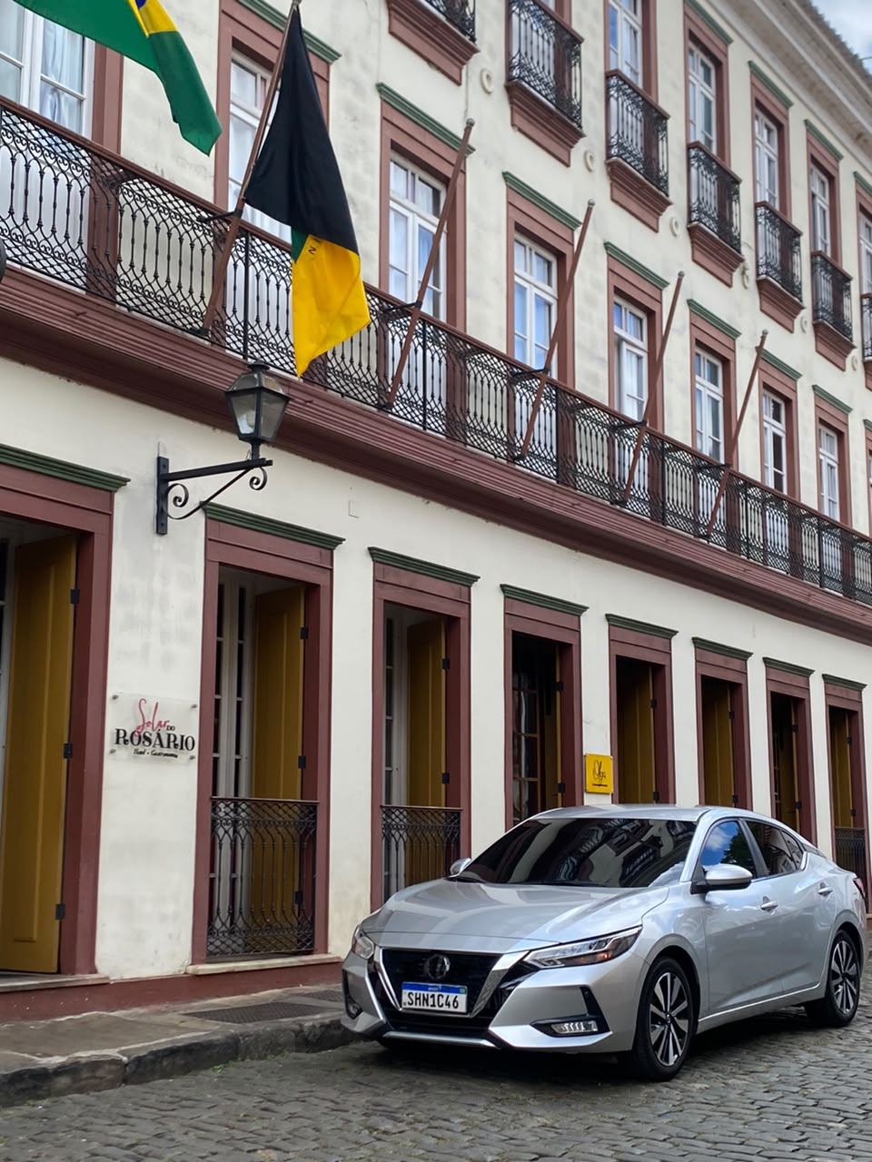Sedan executivo prata em frente a hotel histórico